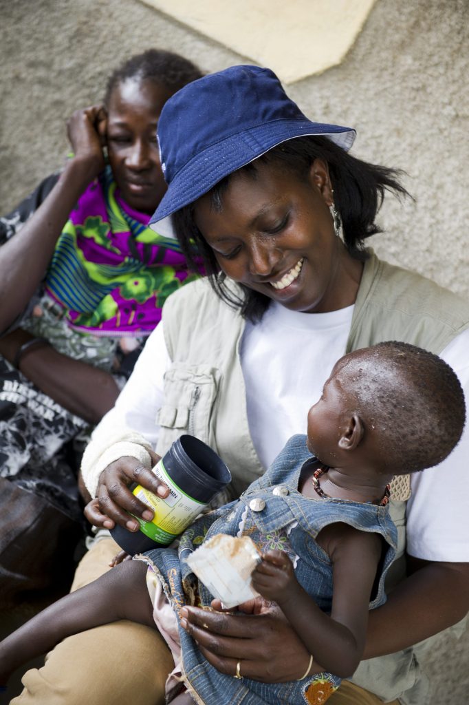 Humanitarian staffer Rose Ogola helps 18-month-old Onrika Nawet drink water in Turkana, Kenya in 2012.