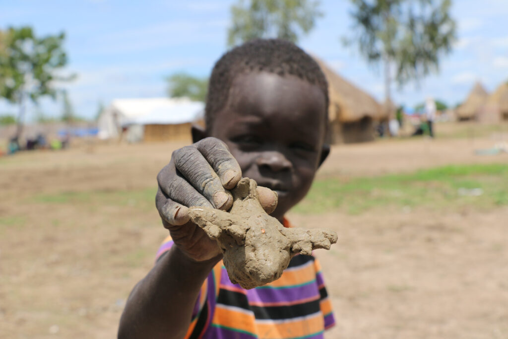 7-year-old Peter Mabor likes to watch WFP's planes fly overhead and offload its cargo. He has observed it so many times that he knows how to construct toy versions of the plane using mud.