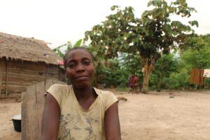 a woman smiles softly in her yard