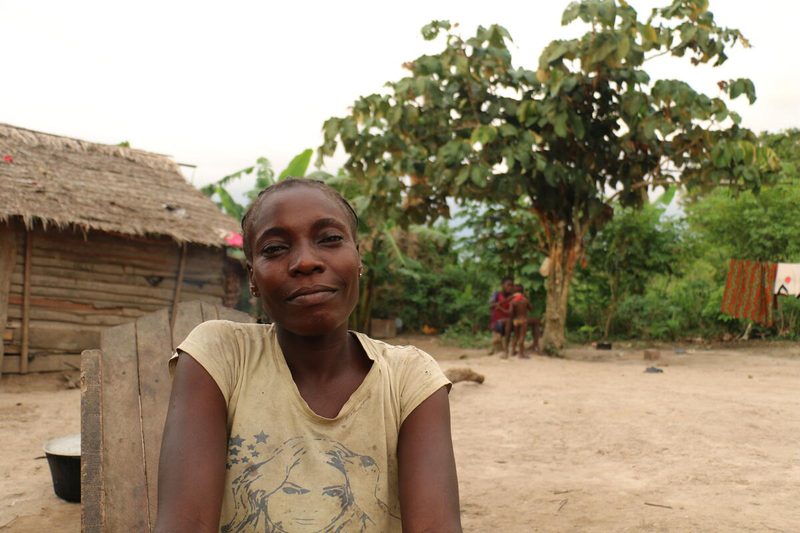 a woman smiles softly in her yard