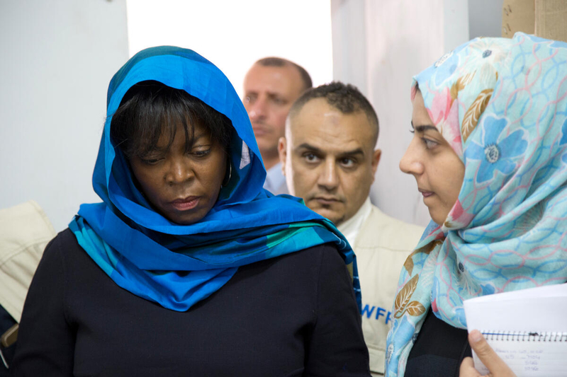 woman in blue headscarf walking with head down