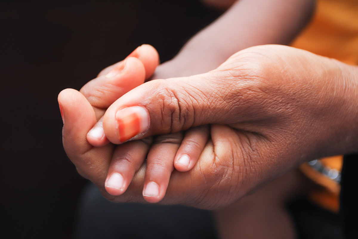 mother holding child's hand