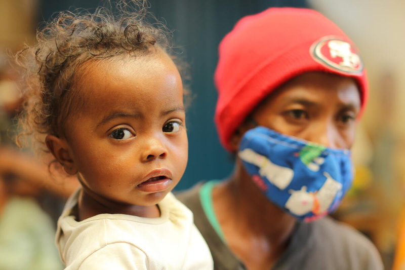 mother in covid health mask holds her daughter