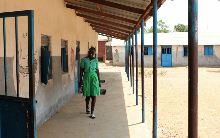 schoolgirl in green uniform smiling and walking