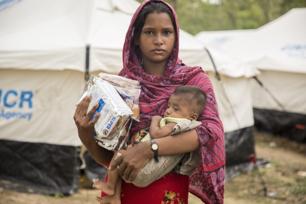 a teenage mom cradles her infant