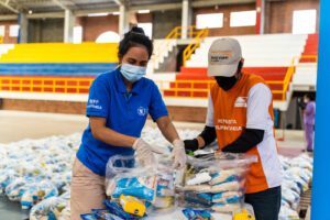 A WFP and World Vision worker organize food for distribution