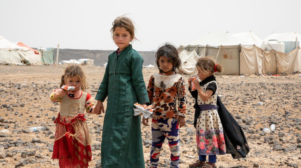 children standing in desert landscape
