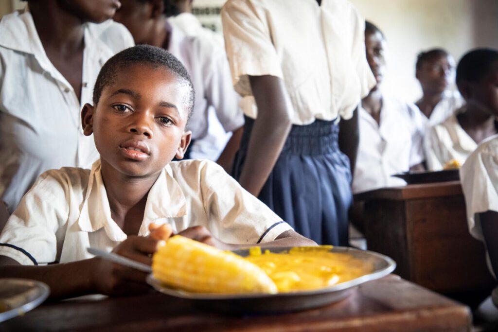 Student in DRC eating lunch