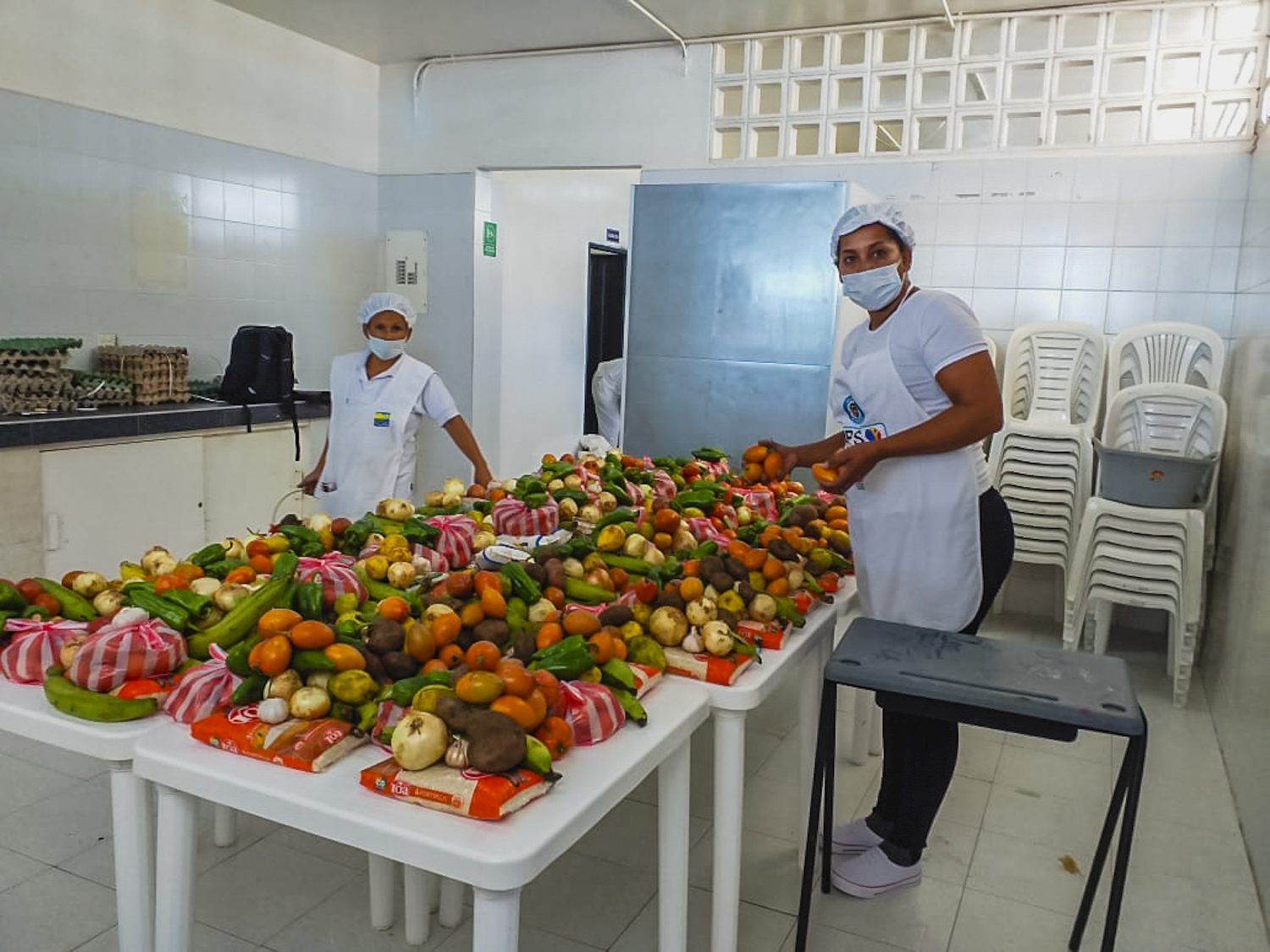 two women prepare take-home food rations