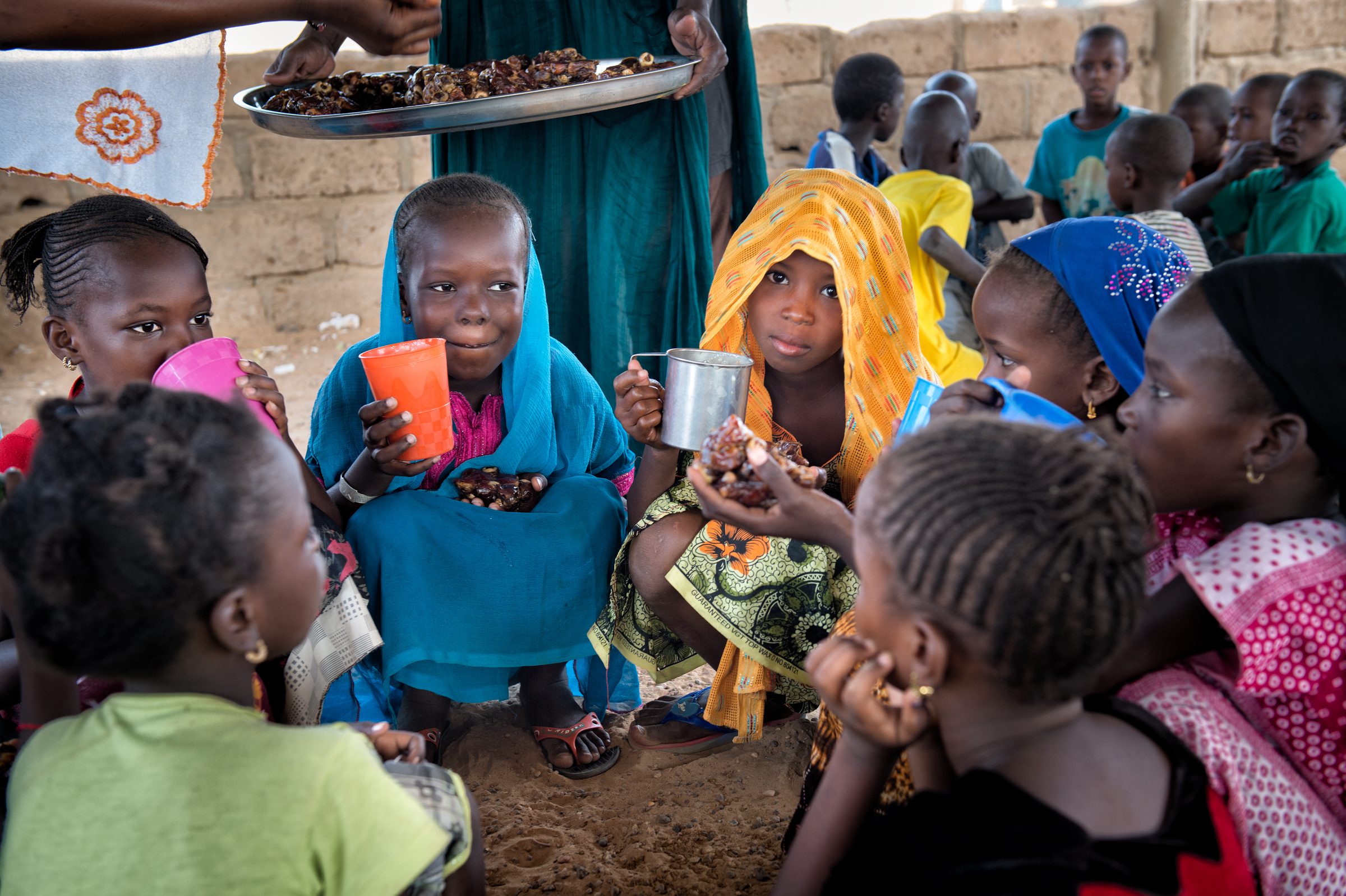 Mauritania, Kaédi, Belinabe village, May 2015

Enrolment in primary school is nearly universal, but retention remains a problem. The percentage of boys completing basic education (42 percent) is higher than that for girls (34 percent). A recent Ministry of Education report indicates that the retention rate is significantly higher in primary school supported by the WFP School Meals Programme (61 percent).
WFP provides school meals to over 150,000 children in areas with high rates of food insecurity and low rates of school attendance or retention.
In the Belinabe village, school managers and parents created a vegetable garden in order to combine school meals with fresh vegetables. This primary school has 336 students, with 207 girls attending classes.

In the photo: Children eat dates provided by Saudi Arabia.

Photo: WFP/Agron Dragaj
 *** Local Caption *** The photo must be credited as follows:
WFP/Agron Dragaj