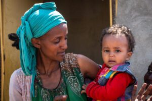 mother in blue turban holds child