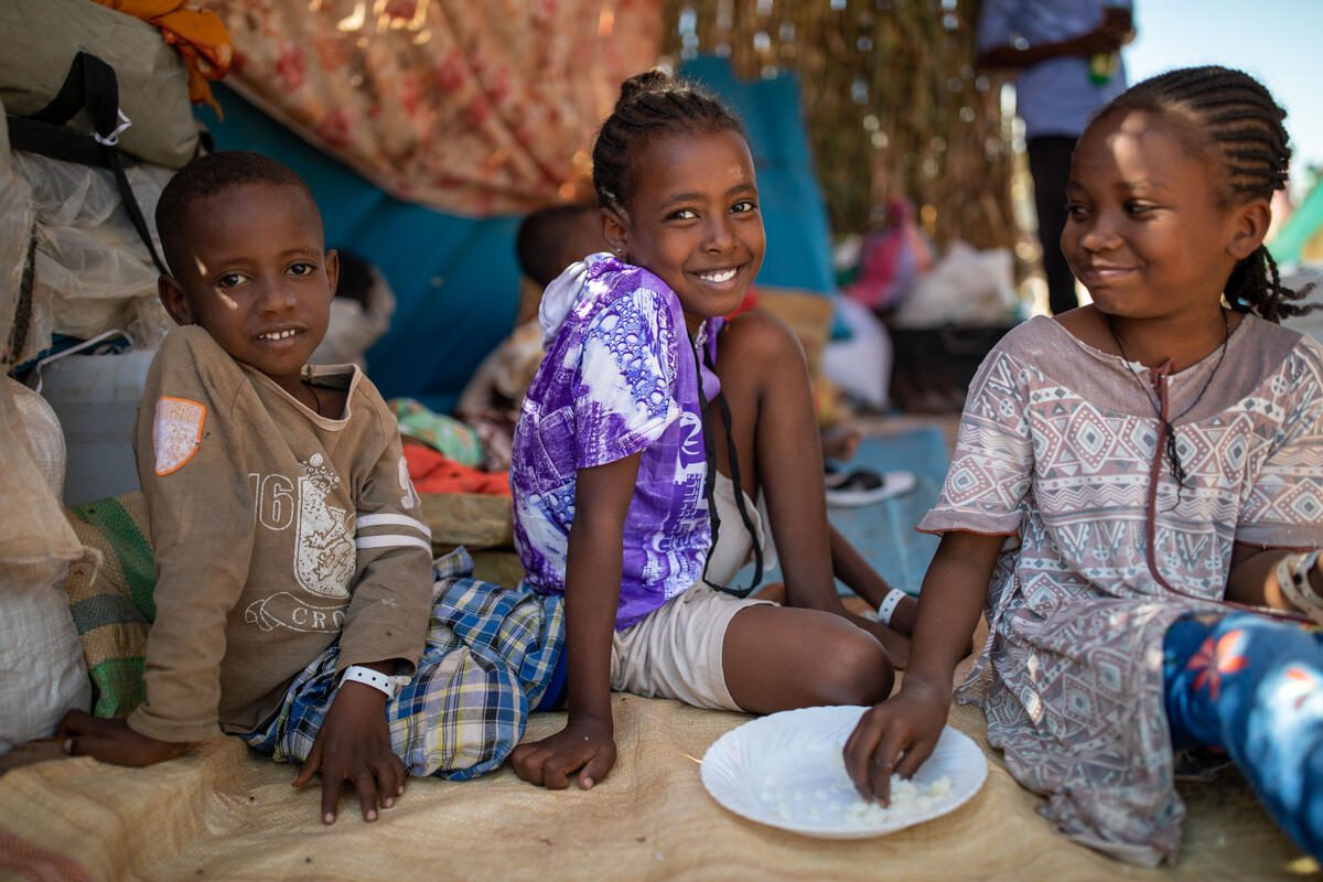 Siblings Berhane* (left, age 6), Halima (middle, age 10) and Makeda (right, age 8) eating rice in a temporary shelter in Um Rakuba refugee camp. The children&#039;s mother Fema has received rations from WFP including millet and oil, to feed her family. WFP continues to support thousands of Ethiopian refugees in Um Rakuba settlement, Sudan, who have fled conflict in the Tigray region, Ethiopia.

*Names changed for protection reasons

The conflict in the Tigray region of Ethiopia that escalated on 4 November, has forced nearly 46,000 Ethiopians to flee across the border into Sudan (as of 1 December). WFP partners are cooking hot meals for refugees arriving at reception centres, using food provided by WFP. Where cooking facilities are not available, WFP supplies fortified high-energy biscuits. Once refugees reach the camps after passing through reception centres, they receive rations including lentils, sorghum, oil and salt.