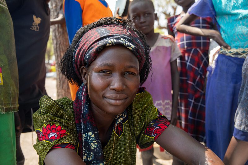 a woman in colorful headband smiles