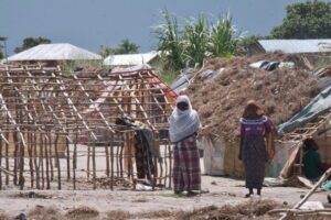 Two women walking around precarious tents in Northern Mozambique