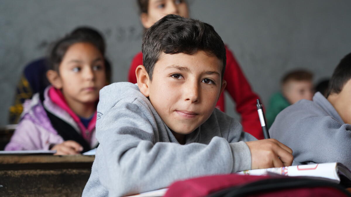 boy studying at a desk in classroom