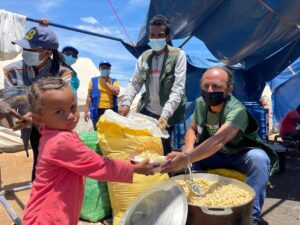 little girl receiving bowl of food