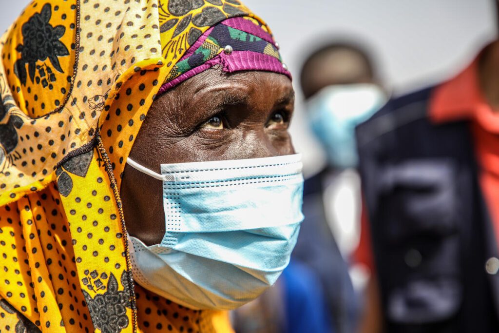 woman in yellow headscarf and COVID-19 safety mask