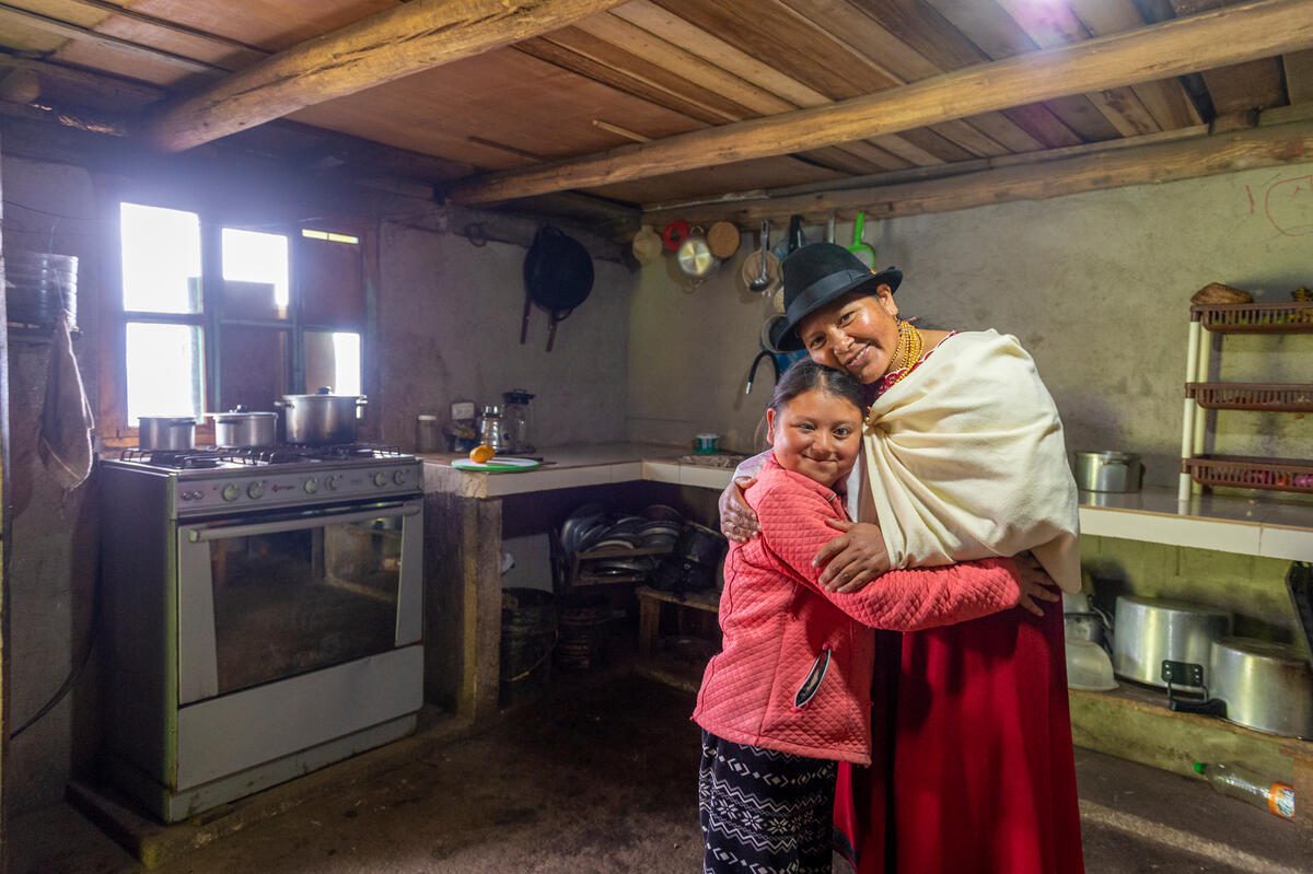 woman in white shawl hugging young daughter