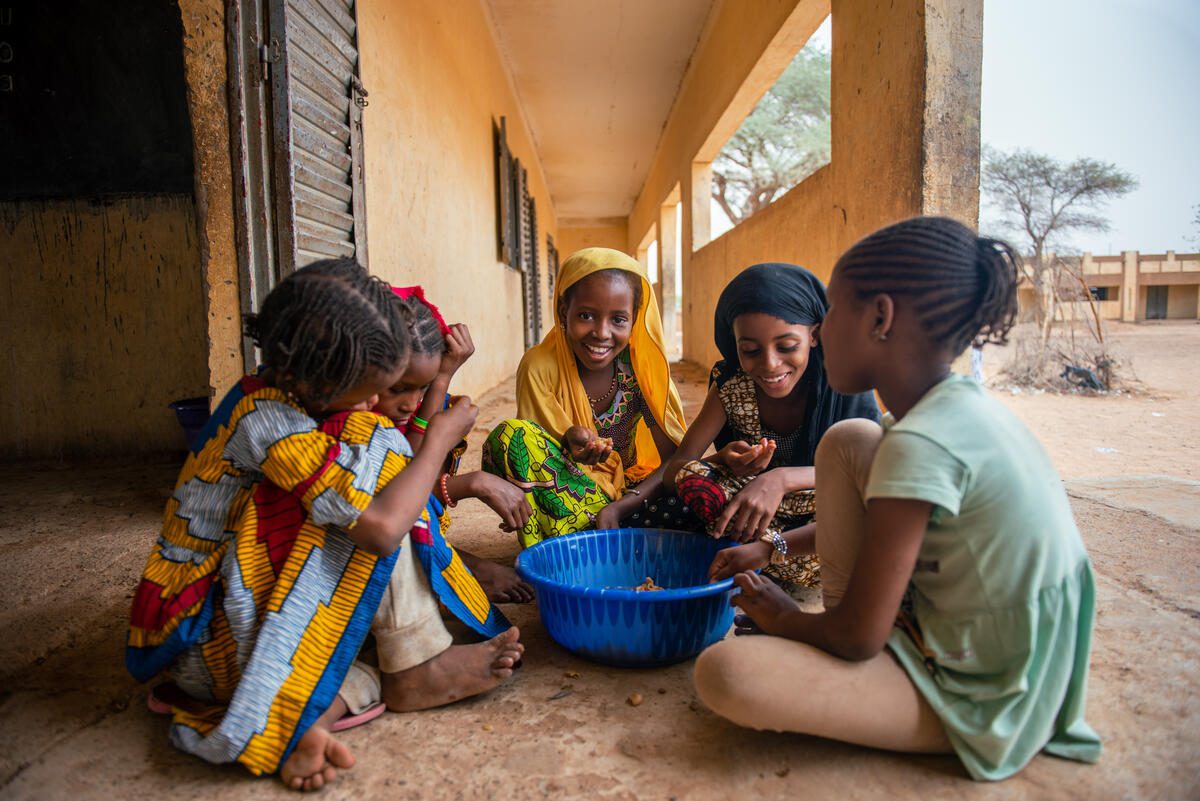 (Yellow hijab) Nafissatou, 11-years-old, and her classmates eat their lunch at the Alpha Amadou Diallo Guetema school, which is supported by WFP in school feeding program in Nioro, Mali, 31 May 2022.