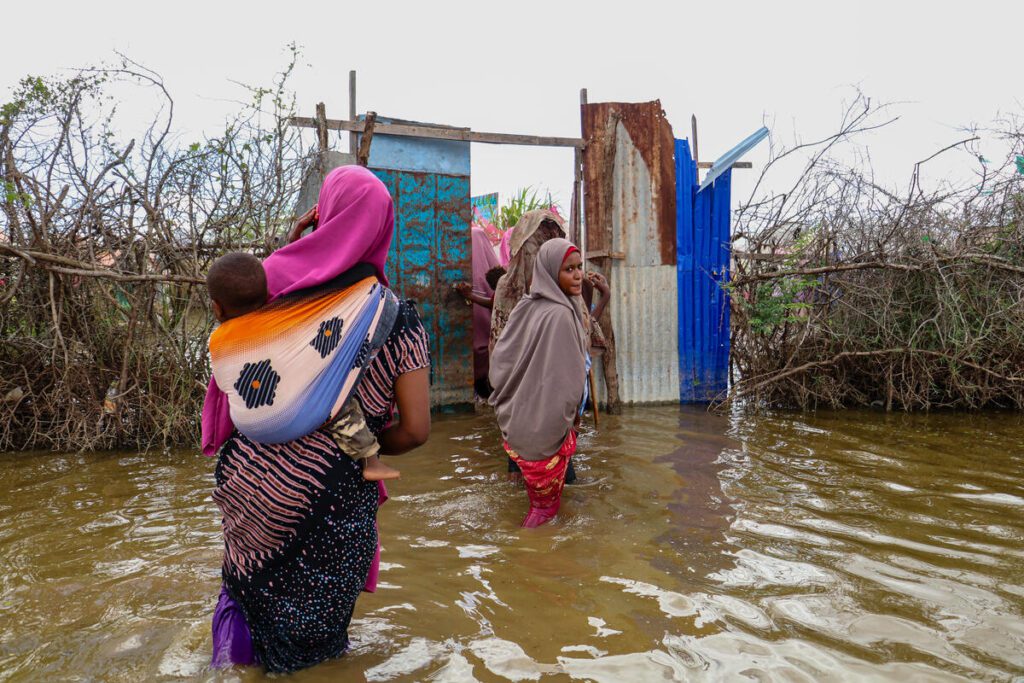 Somali women walk through floodwaters