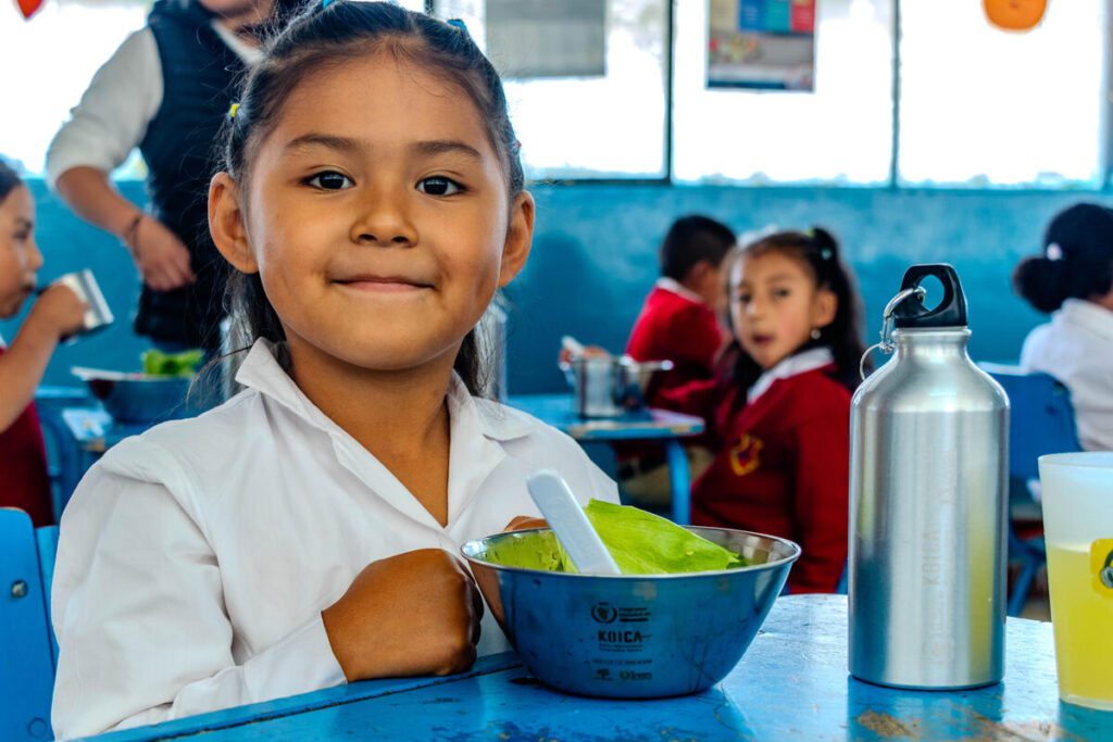 Student eating a school meal in Ecuador