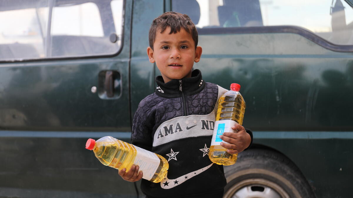 Boy holding WFP food assistance