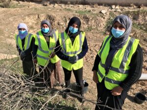 women in yellow vests standing in field