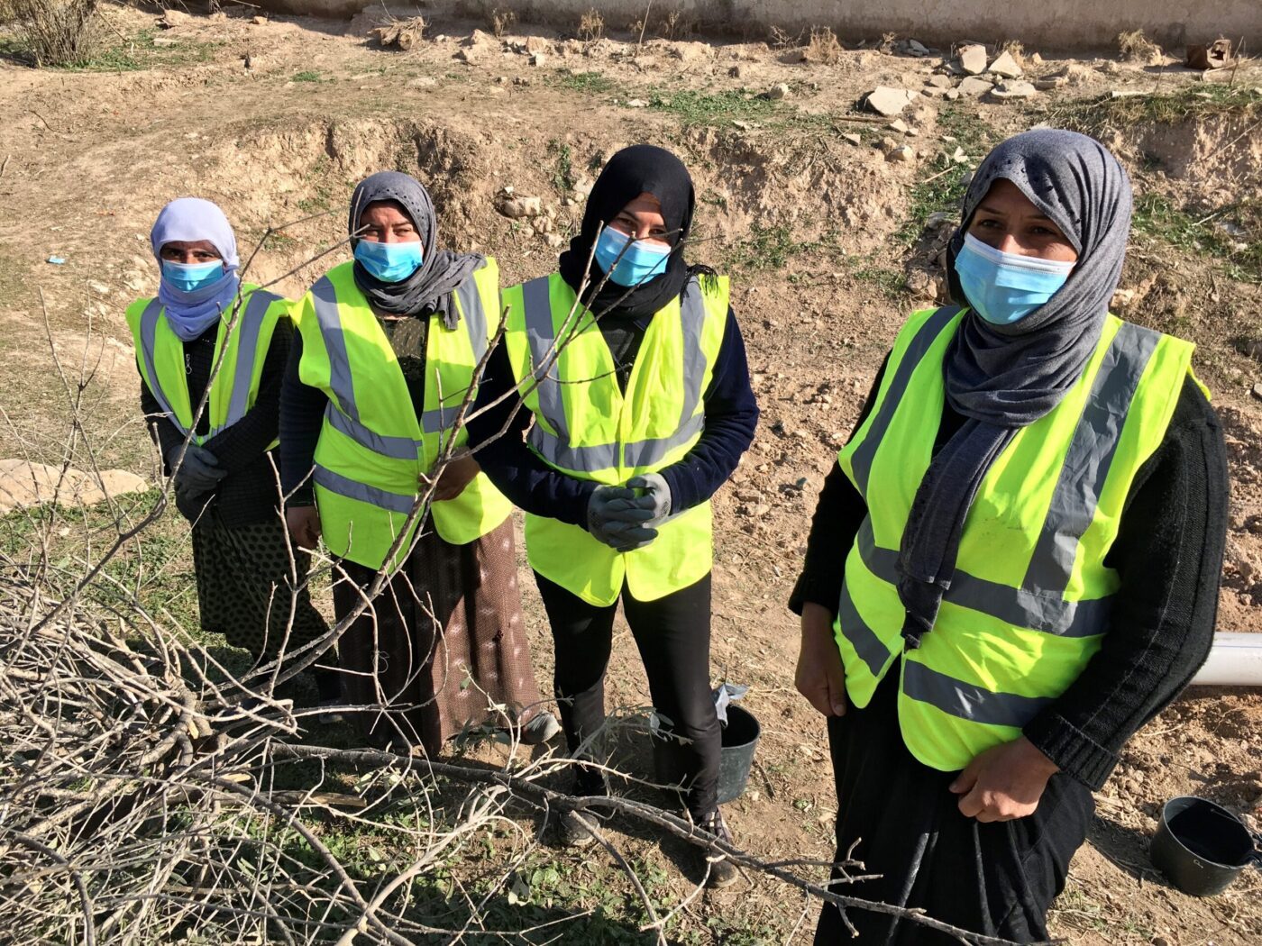 women in yellow vests standing Iin field