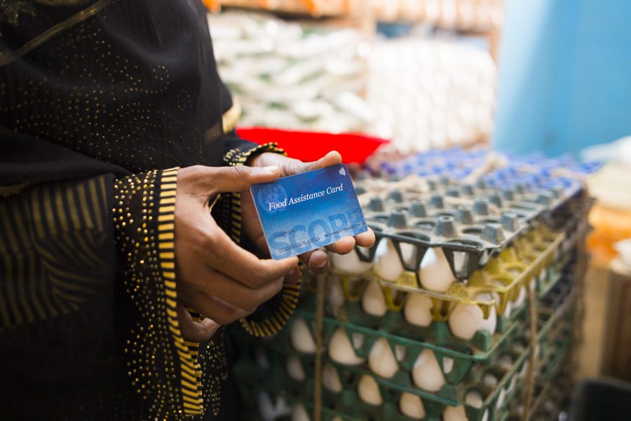 Bangladesh, Balukhali refugee camp, Ukhiya, Coxs Bazar. 13 March 2018.

The recent violence in Myanmars northern Rakhine State has led to mass population displacement both within the country and across the border into Bangladesh. Hundreds of thousands of people have found refuge in makeshift settlements in the area of Coxs Bazar, Bangladesh, where they live in extremely precarious and deteriorating conditions.

90,000 people are enrolled in WFPs e-voucher programme, under which they receive a monthly entitlement on a pre-paid debit card. They can use this in allocated shops to buy 19 different types of food, including rice, lentils, fresh vegetables, eggs and dried fish.

In the Photo: Nur Jahan (25) with her food assistance card in a food shop.  Her husband died and she has three children. 

Photo: WFP/Kauser Haider