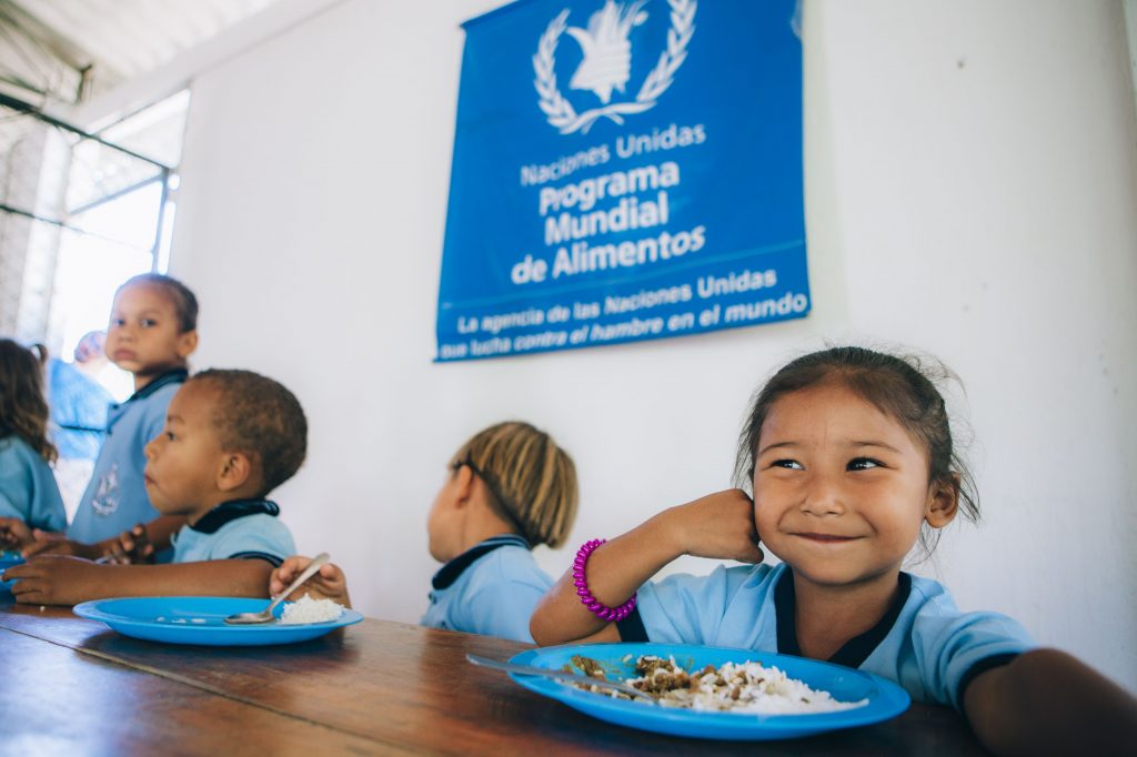 Young girl smiling over plate of food