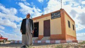 man standing in front of schoolhouse