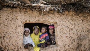 A family looks out the window of their home in Niger