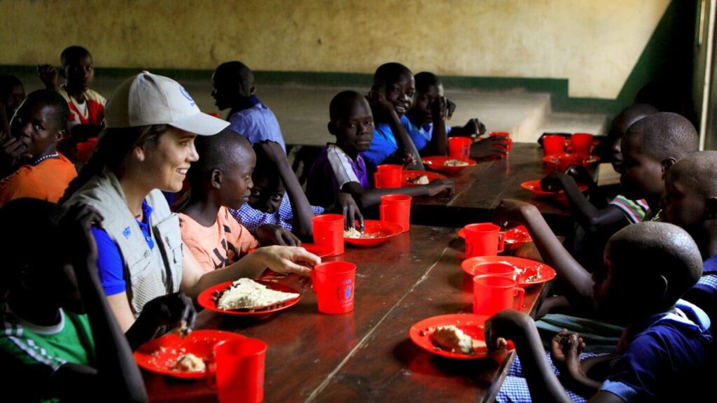 World champion swimmer Natalie Coughlin shares a meal with students at Uganda's Moroto Primary School during a trip with World Food Program USA as the organization's newest ZeroHunger Ambassador.