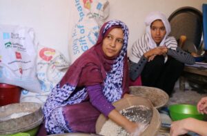 woman in purple headscarf mixing food in bowl