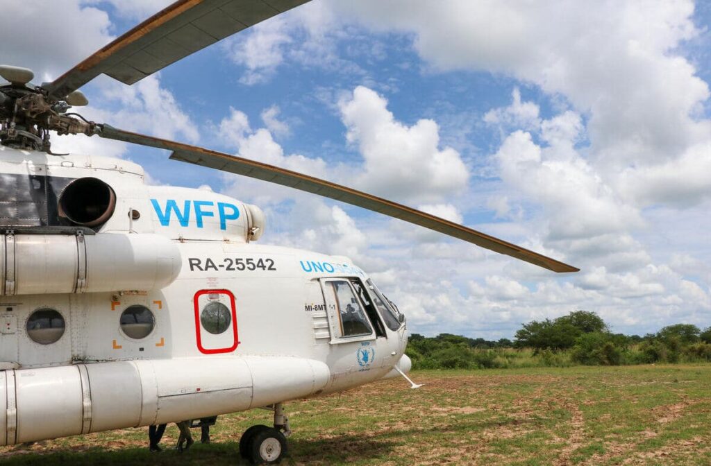 WFP UNHAS helicopter in green field