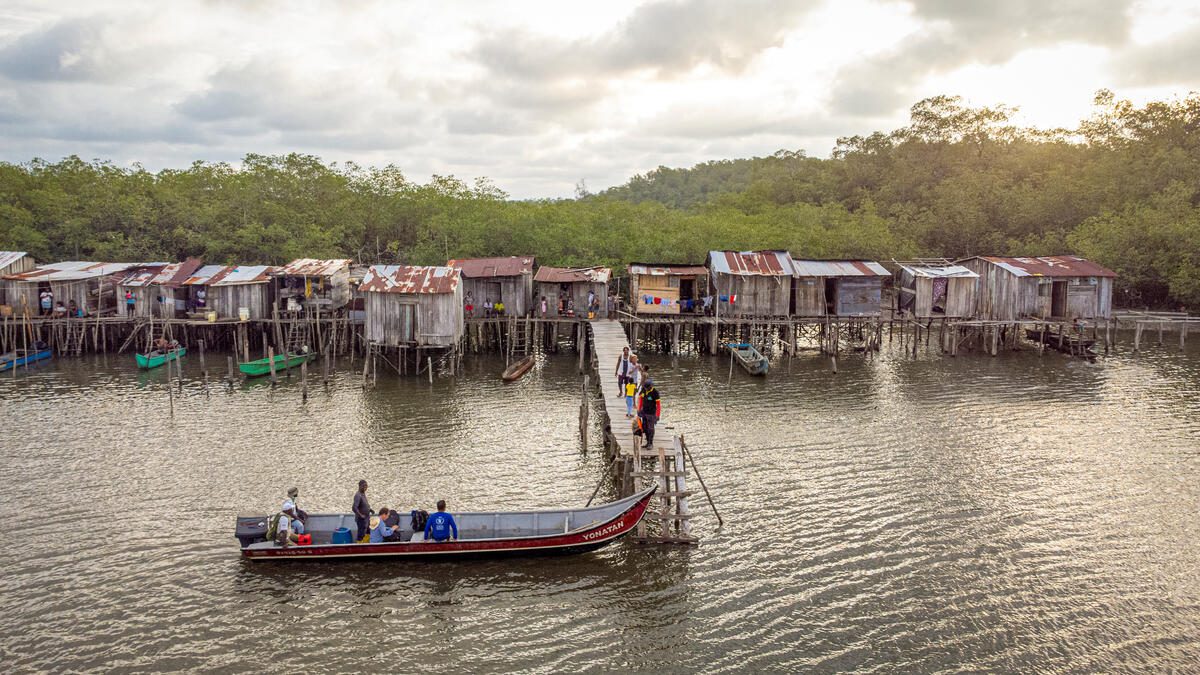 boat floating past community on the water