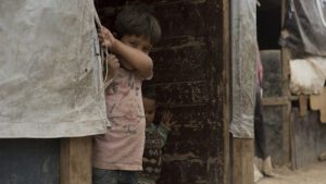 two small children peek out from their house