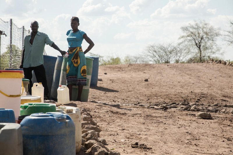 jugs of water and two people standing