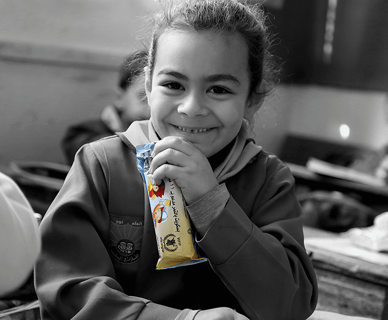 Young girl holding snack bar and smiling